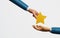Hand holding a star handed over to an employee on a white background