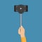 Hand holding stick selfie with smartphone in a flat design
