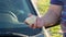 A hand holding a stone after breaking the glass of the car, vandalism.