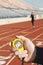 Hand Holding Stopwatch With Runner On Race Track