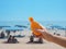 Hand holding sunblock cream bottle over blurred summer beach background