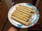 Hand holding taquitos on plate in kitchen