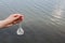 Hand holding test tube for analyses with water on the background of the reservoir, the concept of water purity, pollution of water