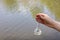 hand holding test tube for analyses with water on the background of the reservoir, the concept of water purity, pollution of water