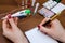 Hand holding thermometer above pills, syringe, tablet, notebook