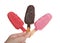 Hand holding three cake popsicles isolated