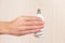 Hand holding a tungsten lightbulb on light wood background