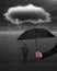 Hand holding umbrella protecting businessman from dark cloud rain lightning