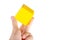 Hand holding up a simple plain yellow floating hovering cube element or node grabbing it between fingers, isolated. Network app