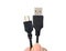 Hand holding usb to micro usb cable on white background