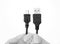 Hand holding usb to micro usb cable on white background