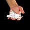 Hand holding a white cotton swab. Close up. Isolated on black background