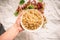 Hand holding white currant berries in a bowl