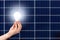 Hand holding white light bulb against solar panel, solar station. Idea concept of alternative energy, technology, environment,