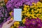 Hand holding a white polaroid paper with colorful vibrant flowers background