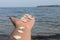 Hand holding white seashells on sea background