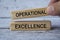 hand holding wooden block with text - Operational excellence. Business concept