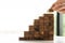 Hand holding wooden blocks stacked in steps on a wooden floor. Business Ideas for Growing Success Handcrafted Wooden Cubes Ladder