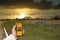 Hand holding a yellow dosimeter showing high radiation, metal sarcophagus of the chernobyl ruined reactor in the distance during a