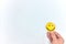 Hand holding a yellow happy face in white background with copy space. Positive customer feedback and review, good service concept.