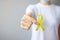 Hand holding Yellow Ribbon for supporting people living and illness. September Suicide prevention day, Childhood, Sarcoma and bone