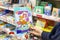 Hand holds a book with stickers in the department of children`s toys in a supermarket.