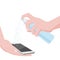 The hand holds a bottle with a disinfectant and sprays it on the surface of the smartphone. Disinfection, the transmission of the