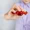 hand holds bright chocolate candy in a red wrapper.