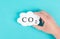 Hand holds cloud with the word CO 2, carbon dioxide emission, environmental issue, air pollution