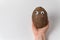 Hand holds coconut with Googly eyes on white background. Crazy nut. Copy space