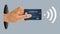 A hand holds a credit card capable of contactless payments via near field communications technology