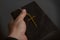 Hand holds the cross and Biblie