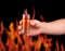 Hand holds glass with pepper vodka on background of flame