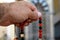 A hand holds an Islamic colorful rosary on a blurred background of the mosque niche Mihrab