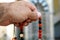 A hand holds an Islamic colorful rosary on a blurred background of the mosque niche Mihrab