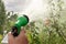 Hand holds manual sprinkler for irrigation and watering garden by water jets