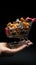 Hand holds mini cart against black background, emphasizing a consumer\\\'s shopping perspective.