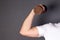 Hand holds Old Sports dumbbell on gray background