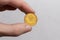 A hand holds a Polish five penny coin on a white background close-up