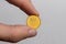 A hand holds a Polish one penny coin on a white background close-up