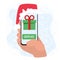 Hand holds a smartphone and orders a gift in the online store christmas distance