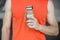 Hand holds sportive bottle of water or sport drink, male body background. Bottle of water in muscular male hand. Sport