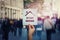 Hand holds a text warning banner on crowded city street. Conceptual social safety awareness campaign for staying home and self