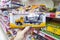 A hand holds a toy car in the department of children`s toys in a supermarket