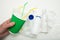 A hand holds a used paper cup on a garbage background. Recycling