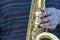 The hand of a homeless musician in gloves on a saxophone