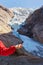 Hand with ice and Briksdal glacier - Norway