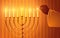 Hand igniting candles on the menorah