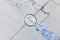 The hand of an industrial worker in a construction glove with a magnifying glass examines the damaged tile background. Renovation