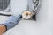 Hand of industrial worker in construction glove with magnifying glass examines rust on old air conditioner against white wall